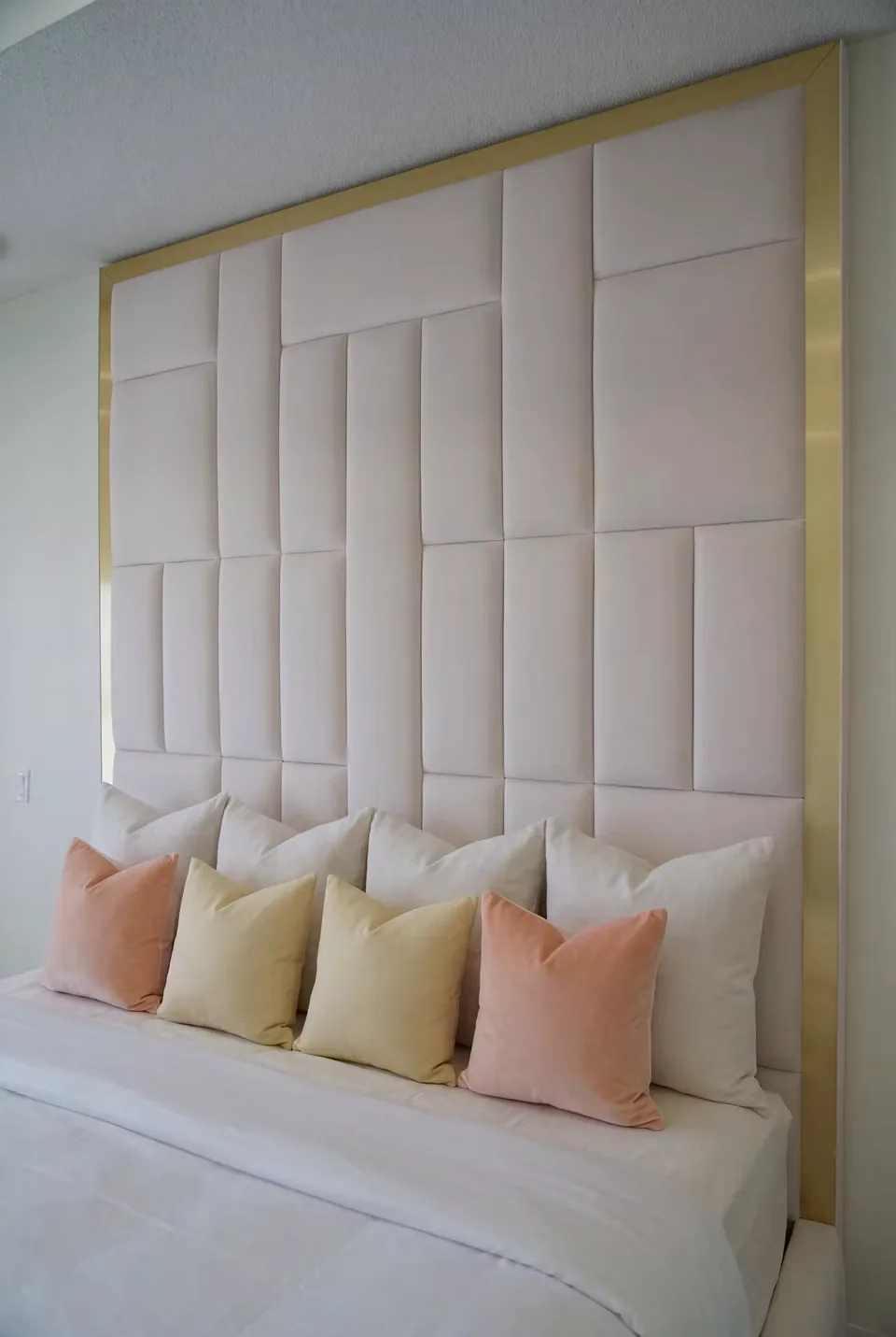 Close view of ivory headboard blocks with blush and cream cushions