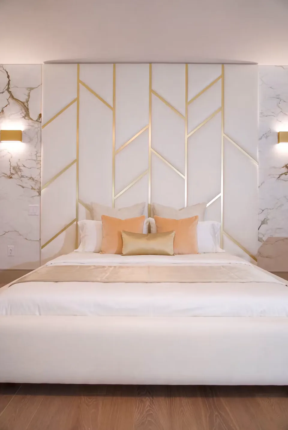 Front detail of cream wall panels and gold-toned branches above peach cushions