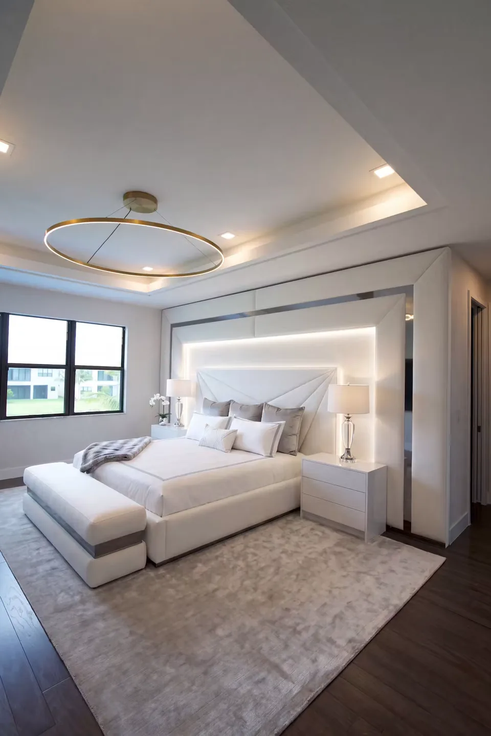 Full angled view of the pale upholstered bed and framed wall