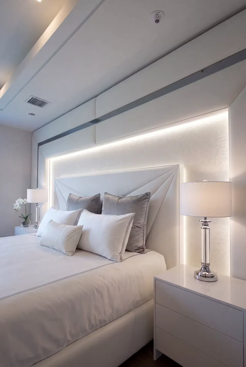 Close view of the ivory geometric headboard beside a bedside lamp