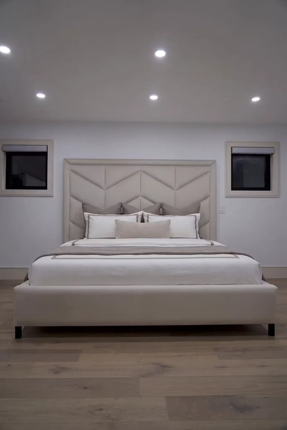 Full front view of the ivory bed between two small windows
