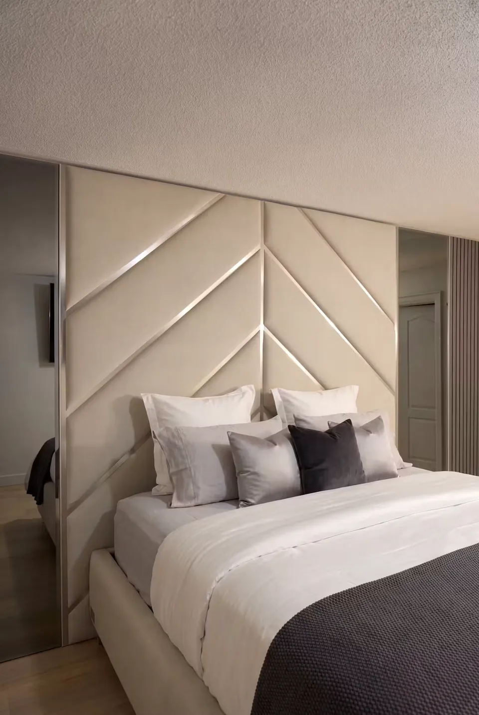 Front angled view of the ivory chevron bed wall and dark throw.