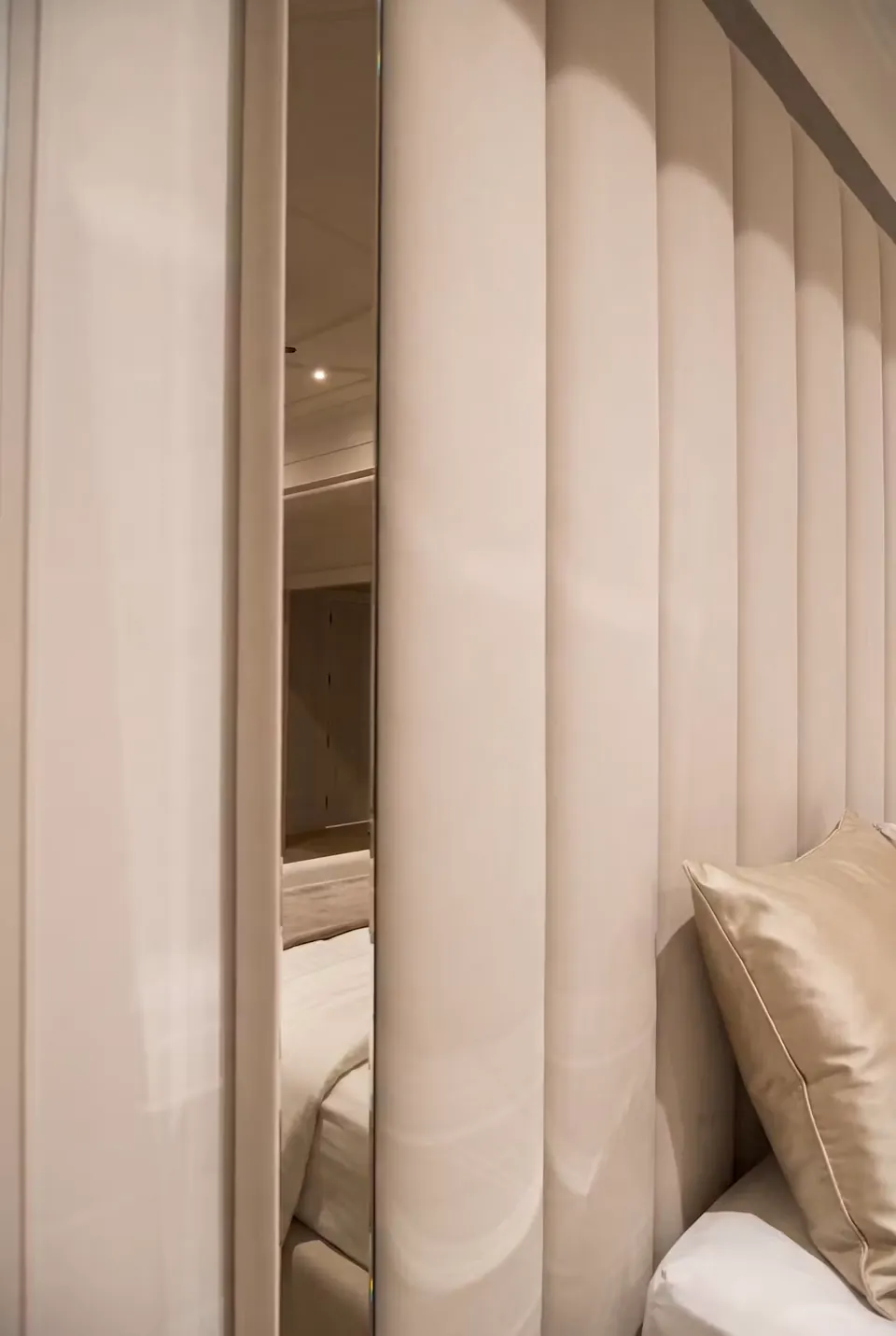 Close view of ivory padded columns alternating with narrow mirrored strips.