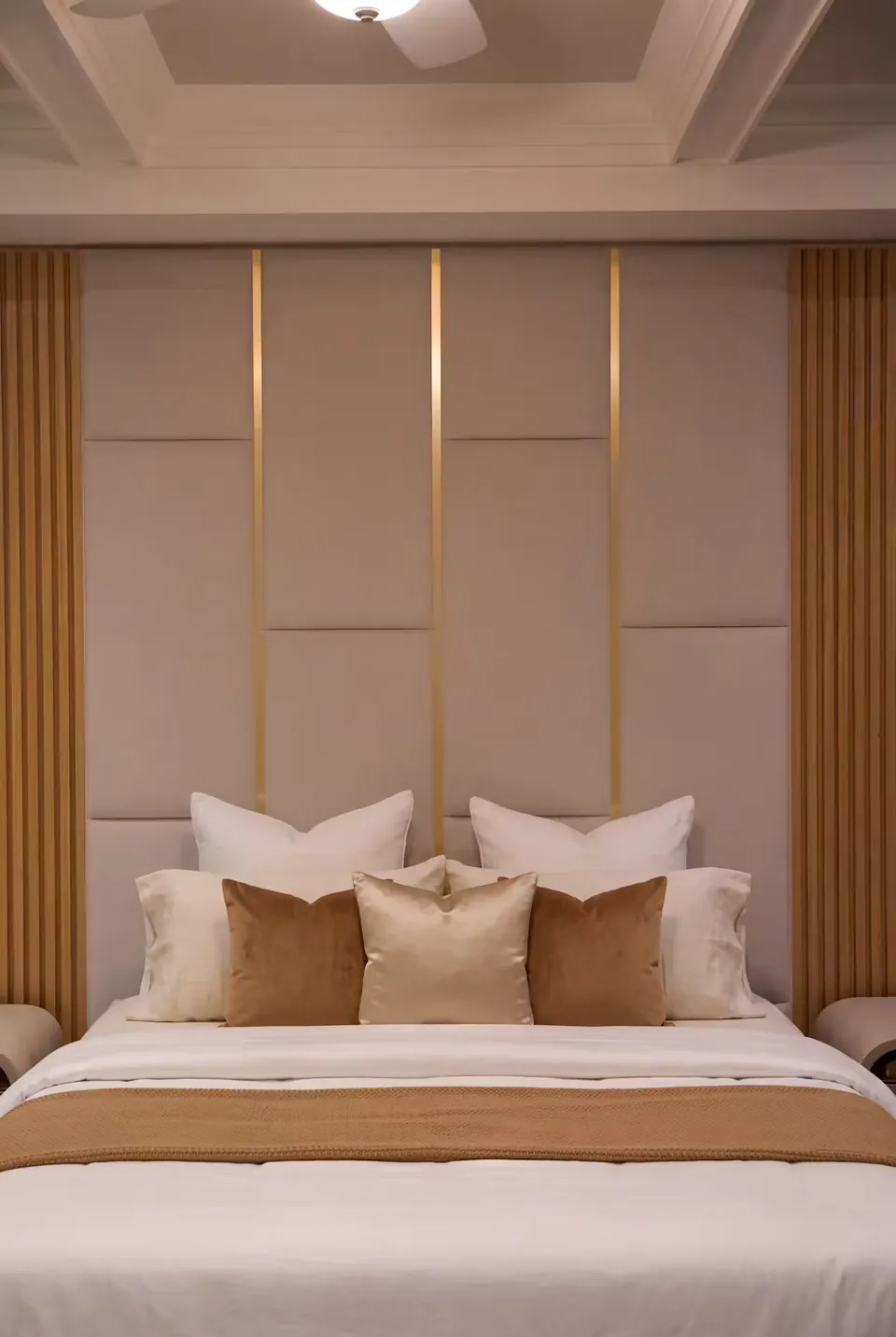 Front detail of ivory padded rectangles, gold accents and tan bedding.