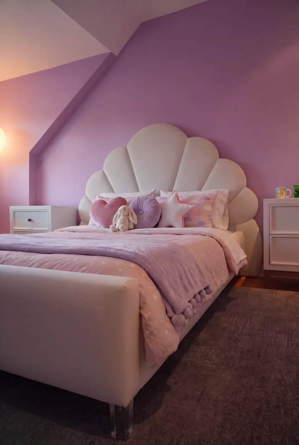 Ivory petal-shaped headboard and upholstered bed with pink bedding against a purple wall