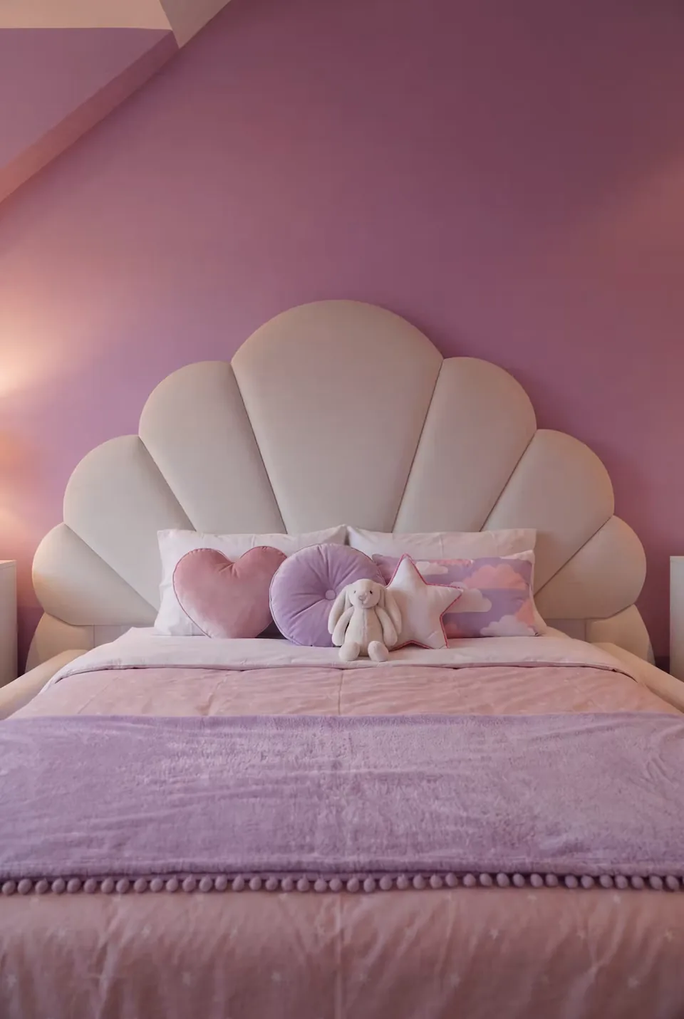 Front view of the pale scalloped headboard with lilac bedding and cushions