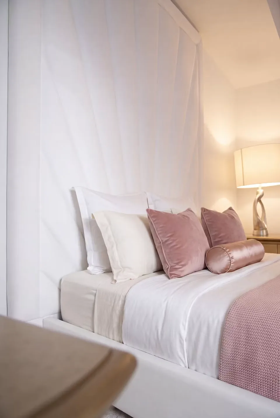 Close view of tall ivory rays beside white and pink pillows