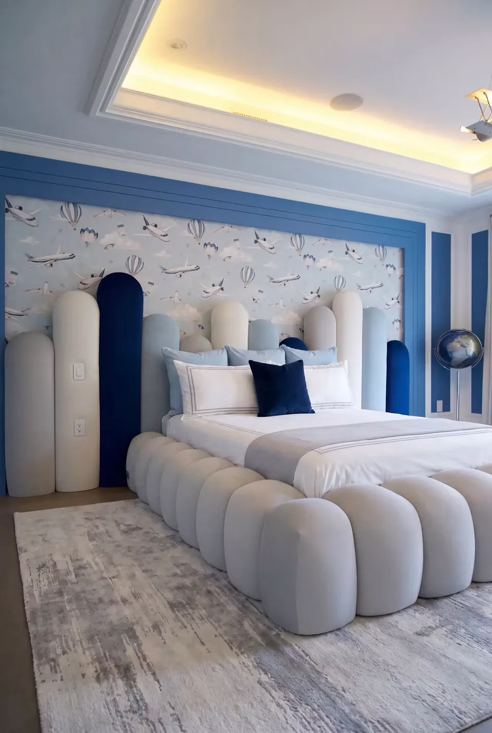 Angled view of the ivory rounded bed frame and playful padded headboard