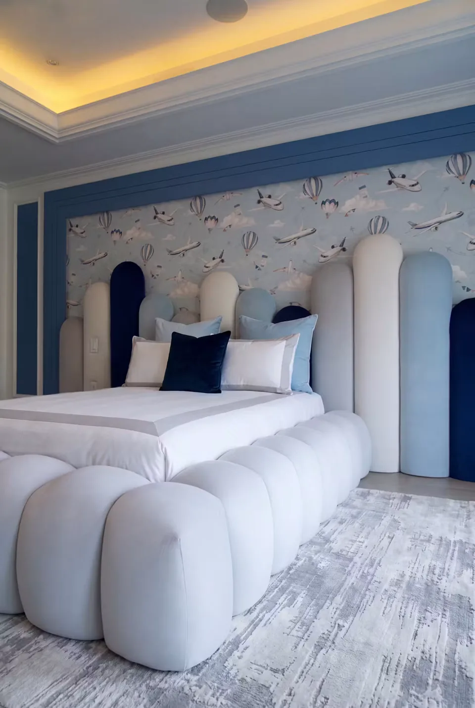 Closer view of the rounded ivory footboard beside the bed