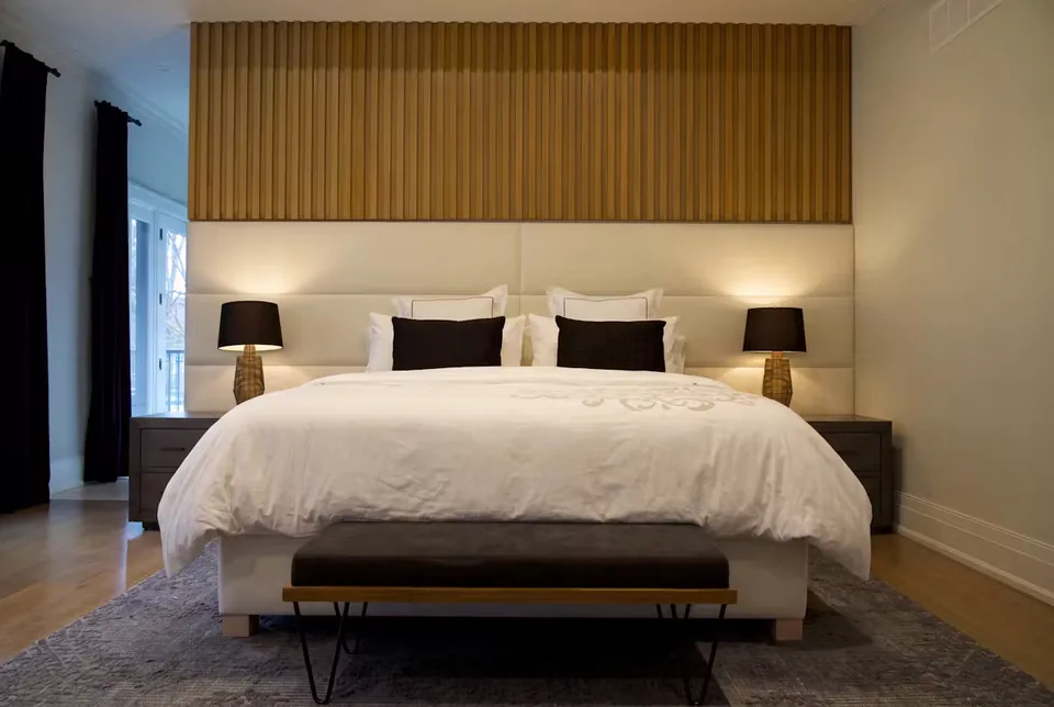 Full front view of the pale bed, dark bench and slatted wall band
