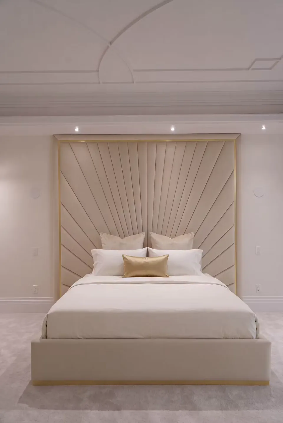 Full ivory bed with a framed sunray upholstered wall and gold-toned base