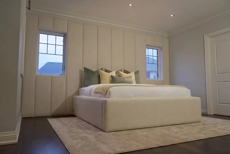 Wide side view of the ivory bed and padded window surround