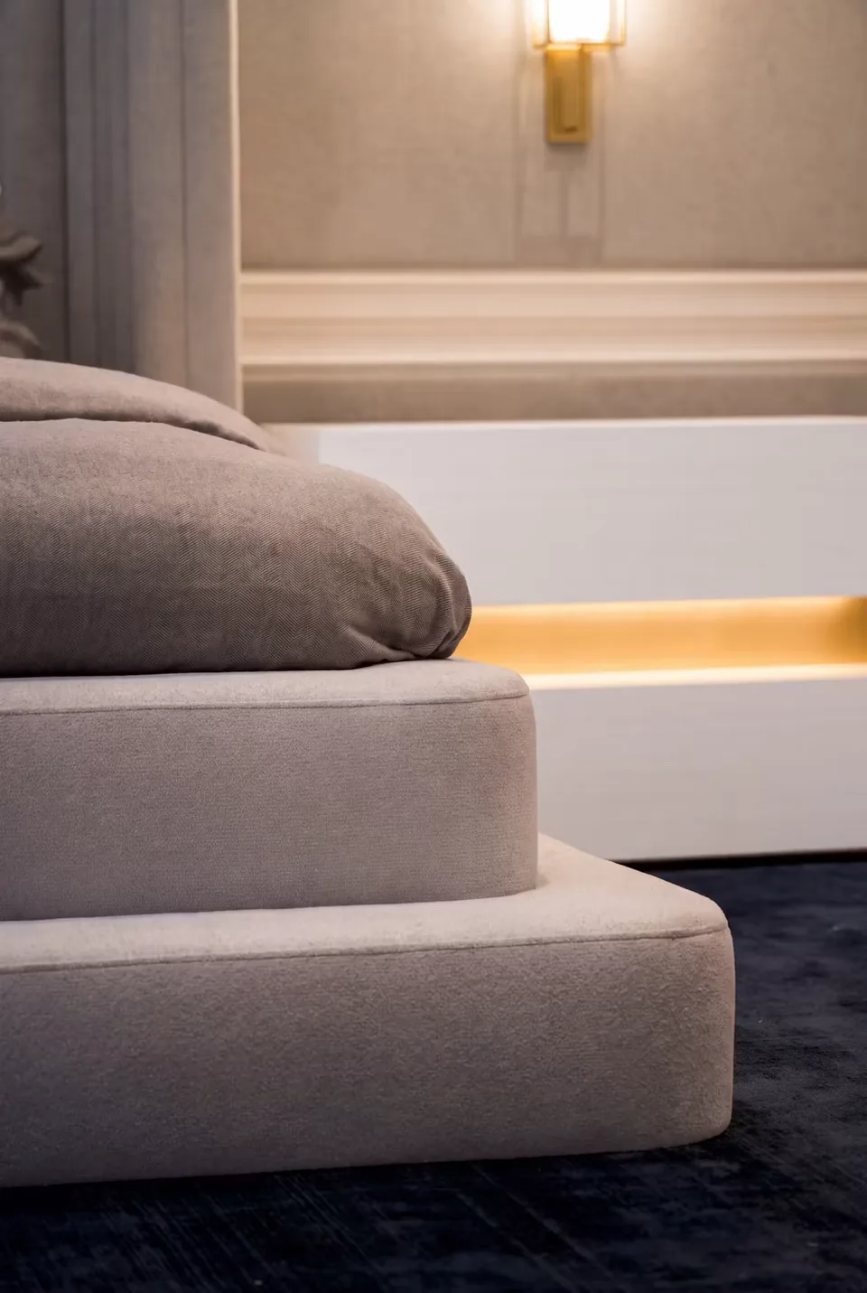 Detail of the two upholstered levels at the side of the grey bed base
