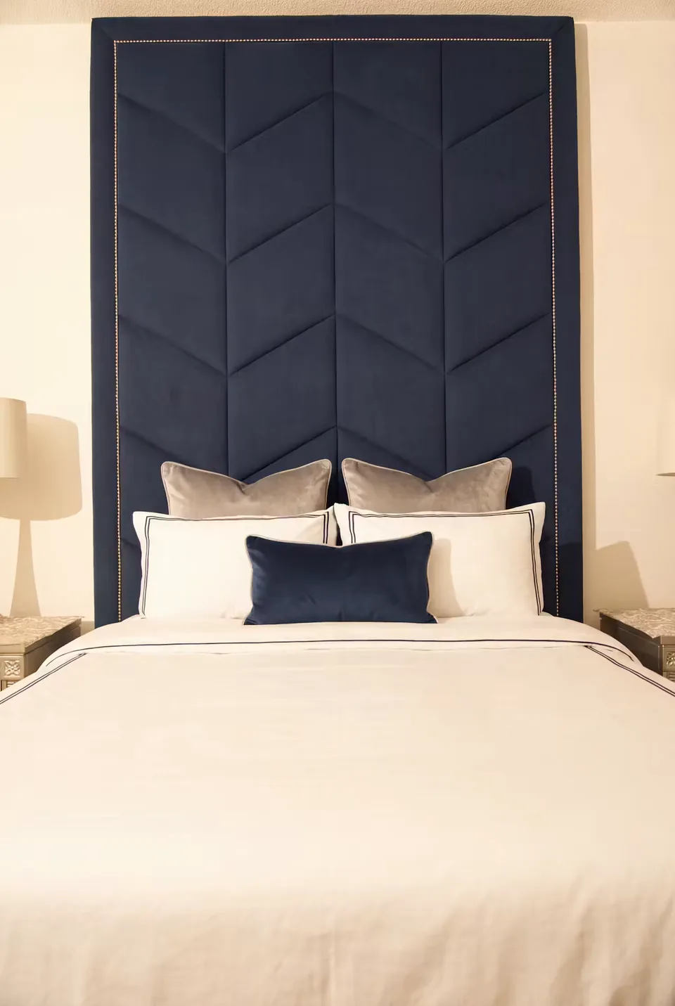 Front view of the navy headboard above white bedding