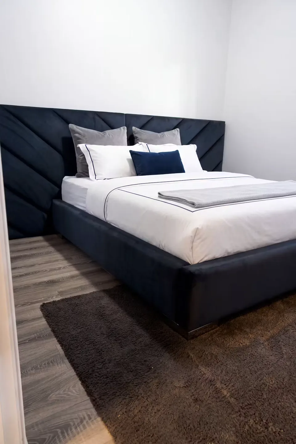 Portrait view showing the navy bed and diagonal padded wrap