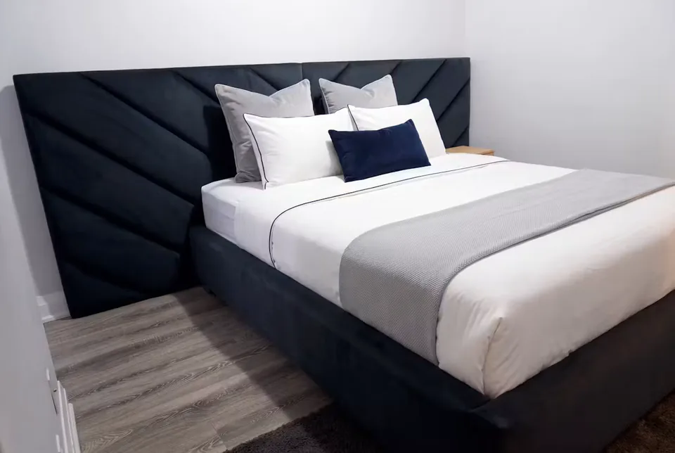 Full angled view of the navy frame and upholstered corner wall