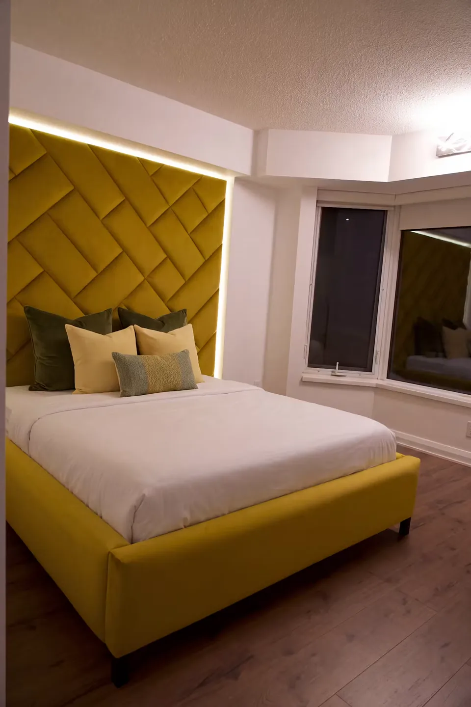 Full angled view of the ochre bed and interlocking upholstered wall