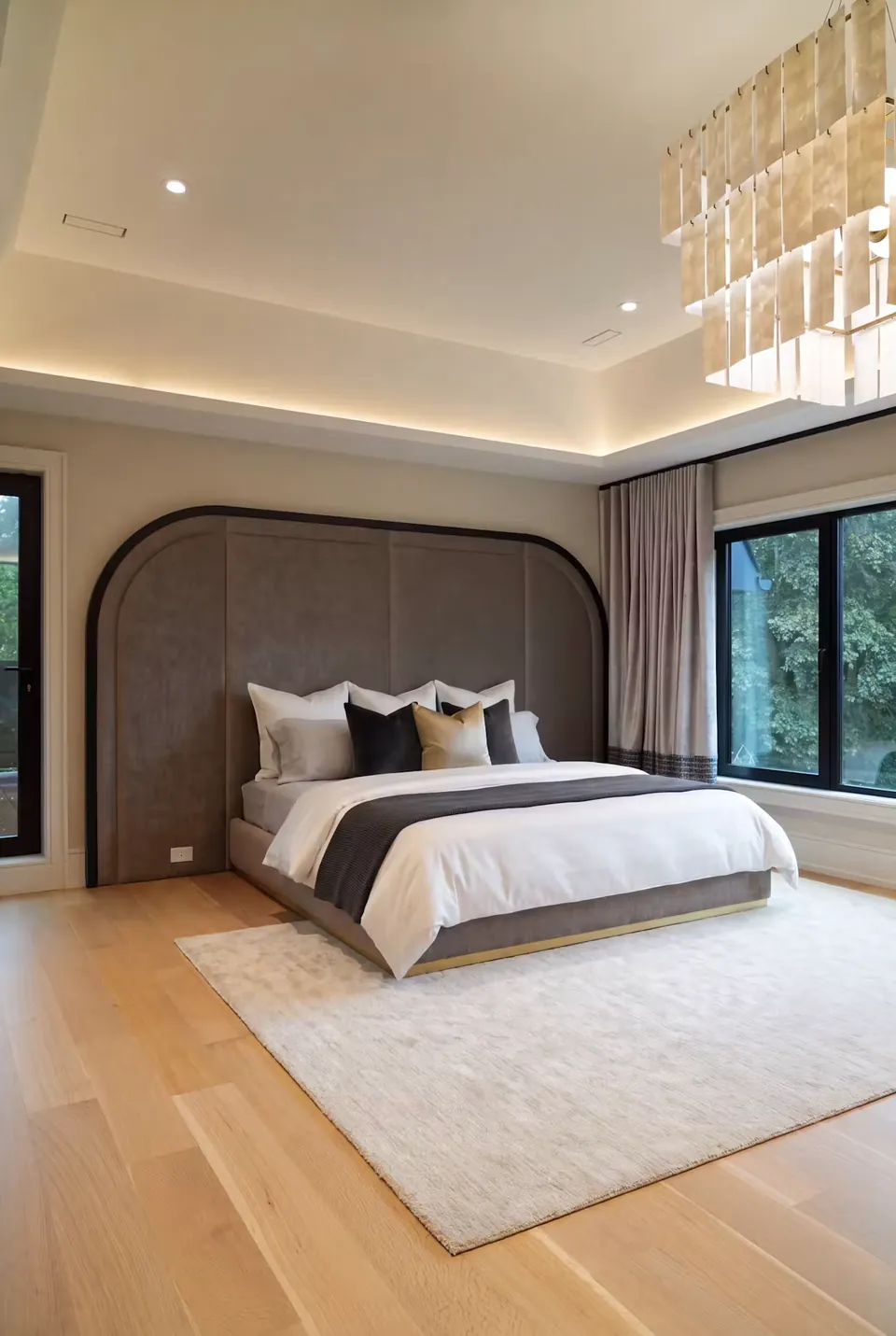 Full angled view of a grey upholstered bed with a rounded black-bordered headboard wall.