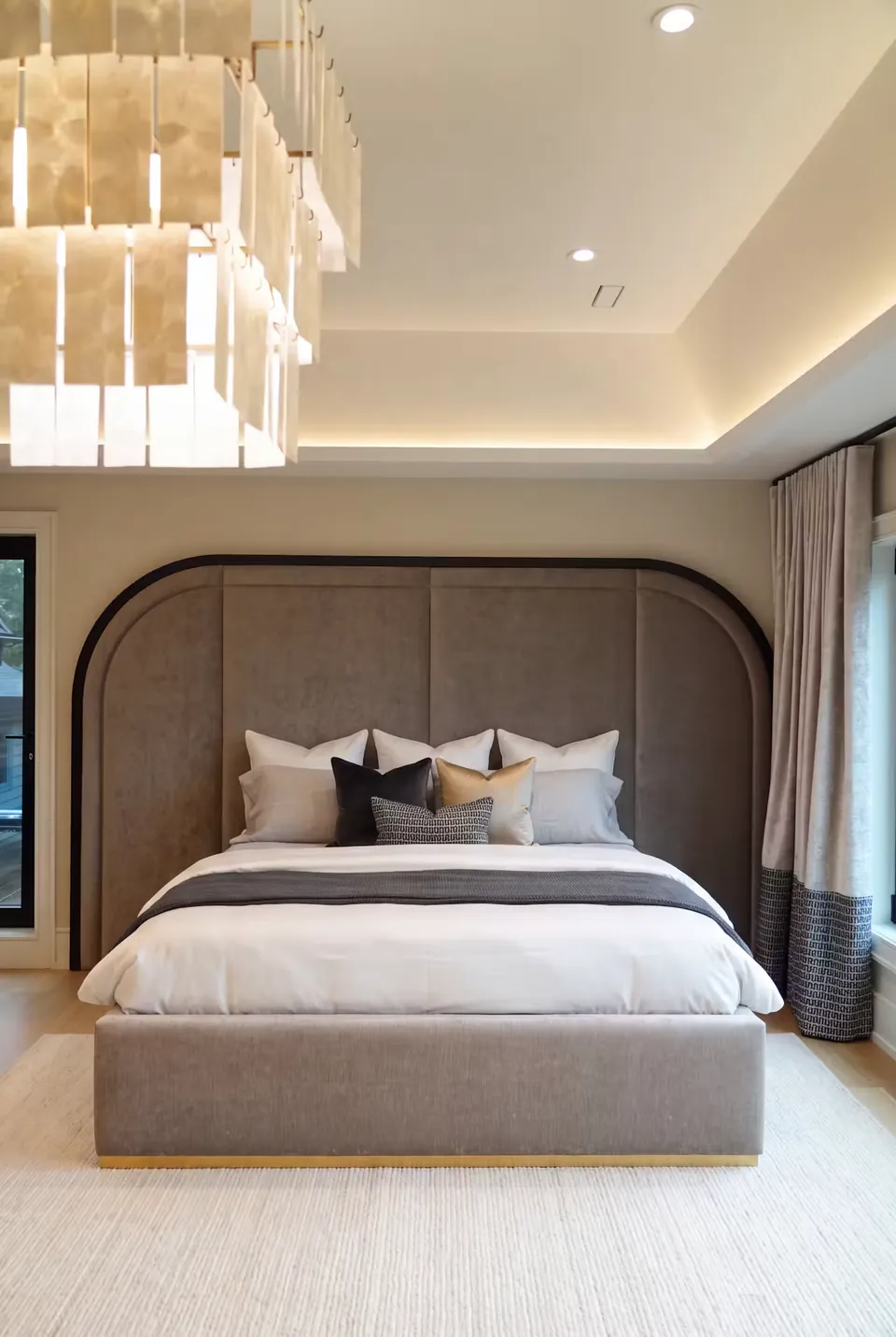 Front view of the grey bed beneath a broad rounded upholstered backdrop.