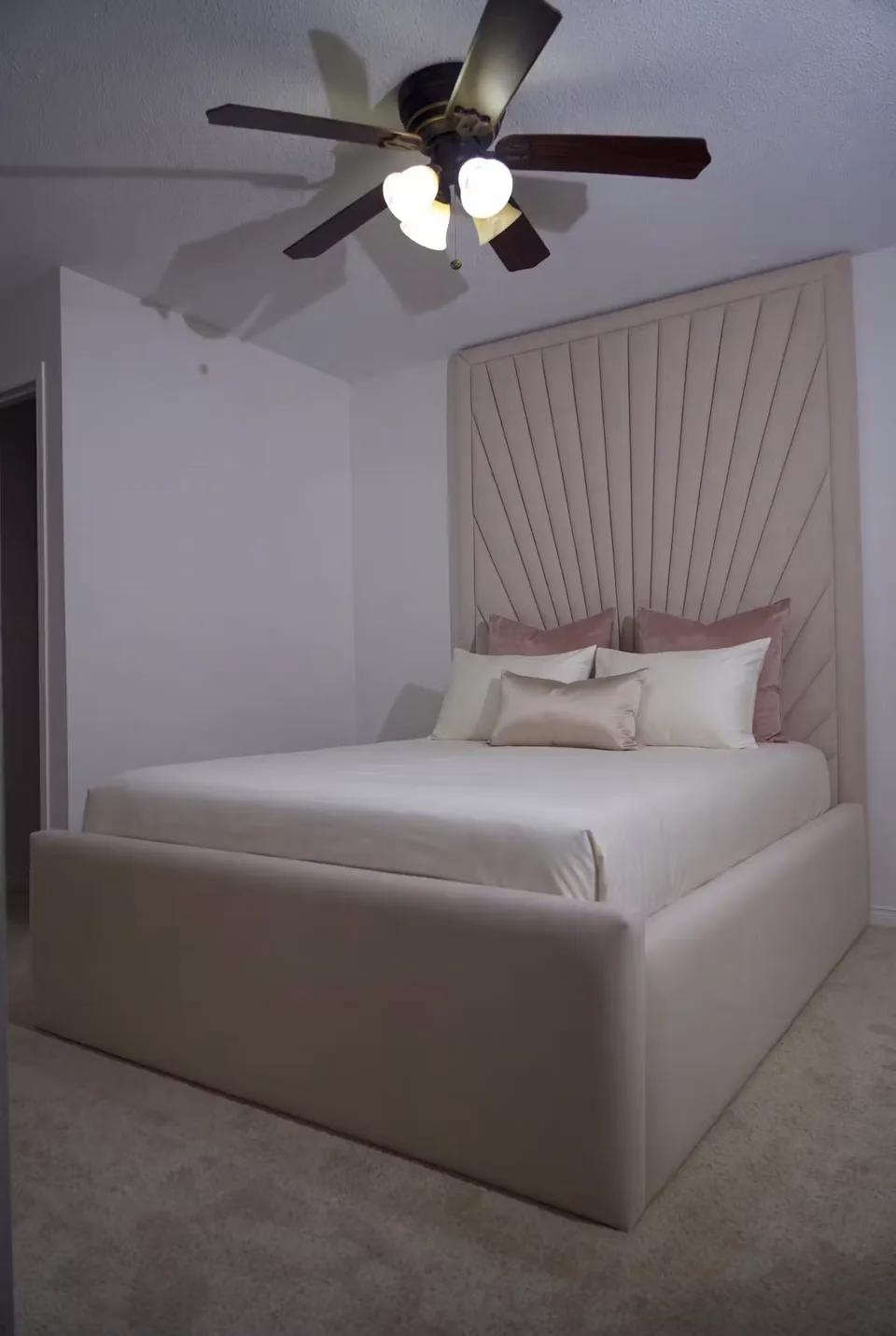 Full sand upholstered bed with a tall framed fan headboard