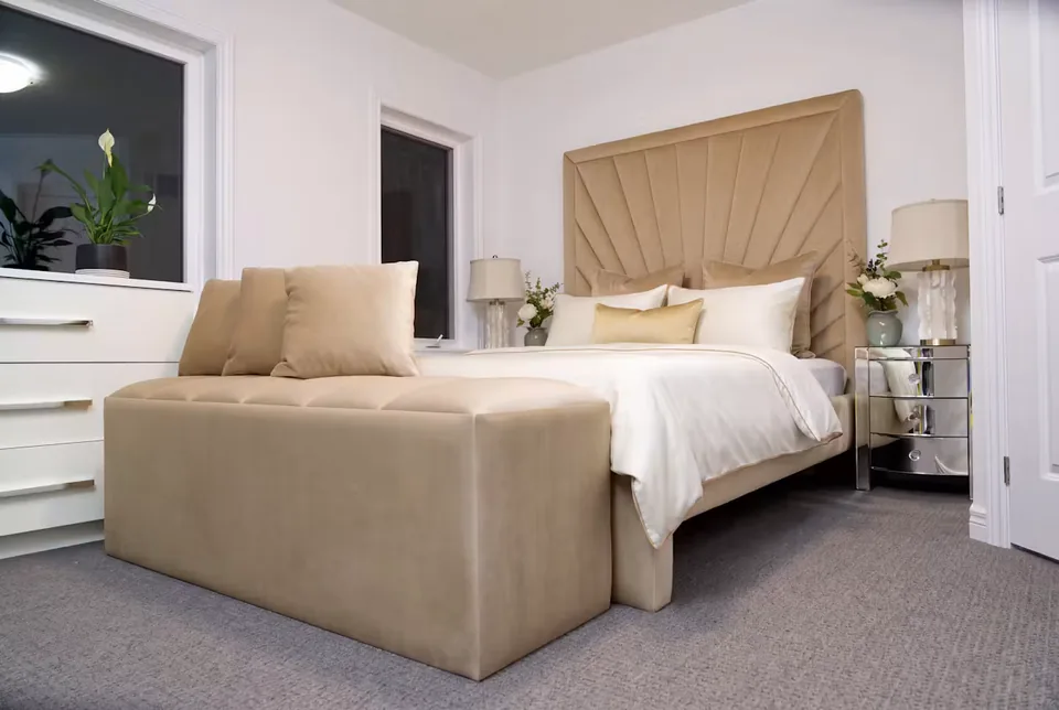 Wide room view of the sand bed, padded bench and framed fan headboard
