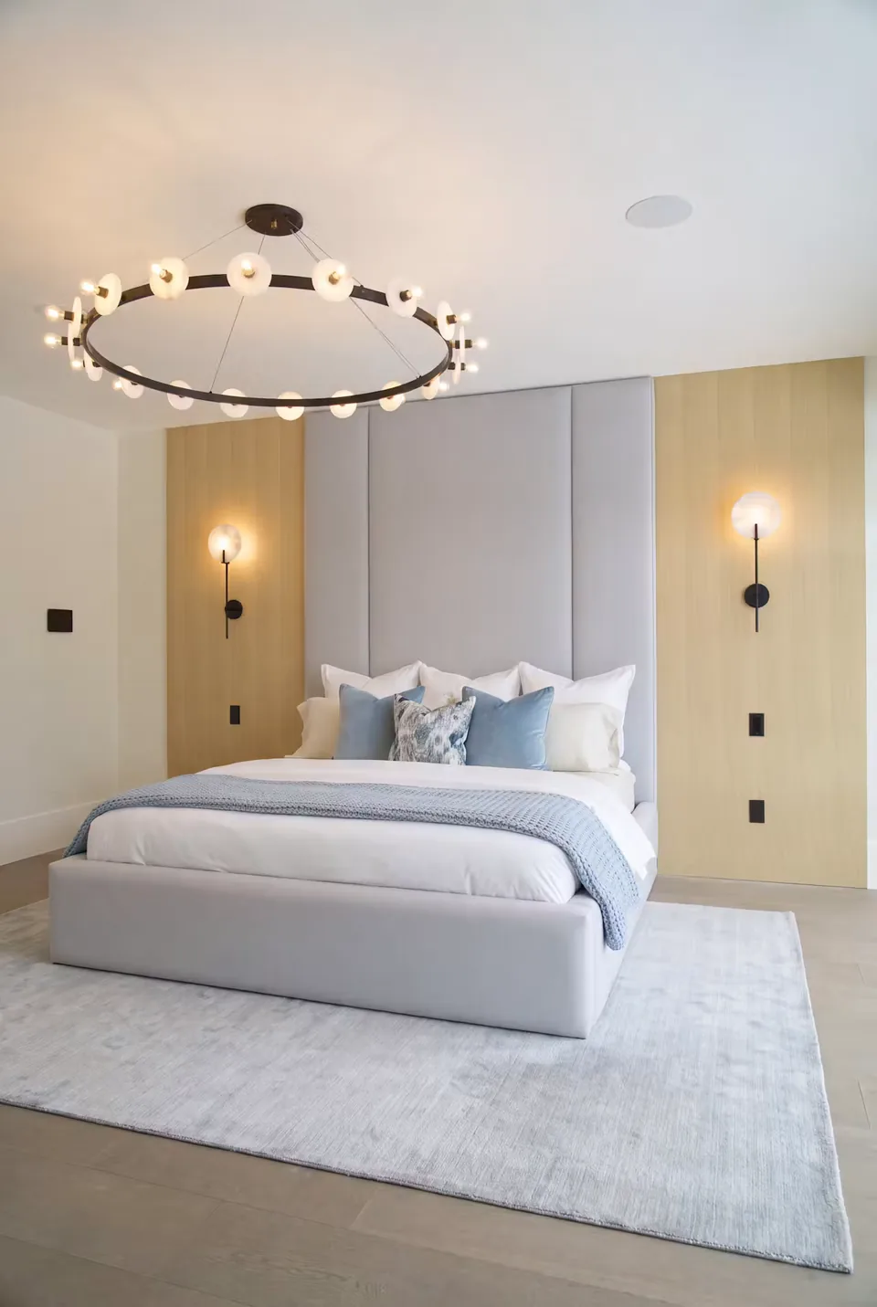 Wider angled view of the silver-grey bed, broad headboard panels and pale vertical side sections.