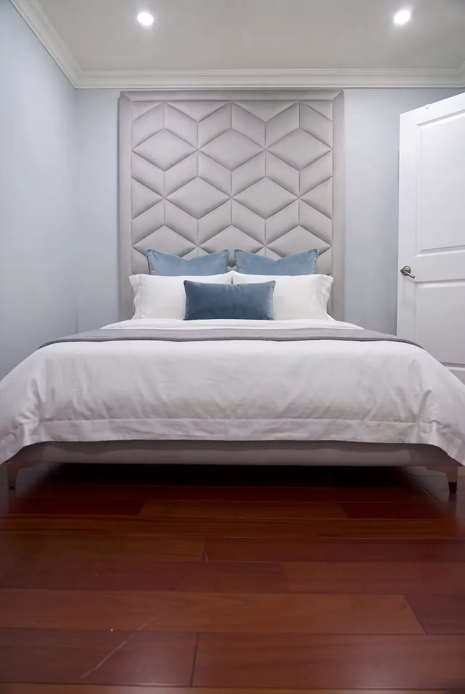 Silver upholstered bed with a tall stacked-diamond headboard