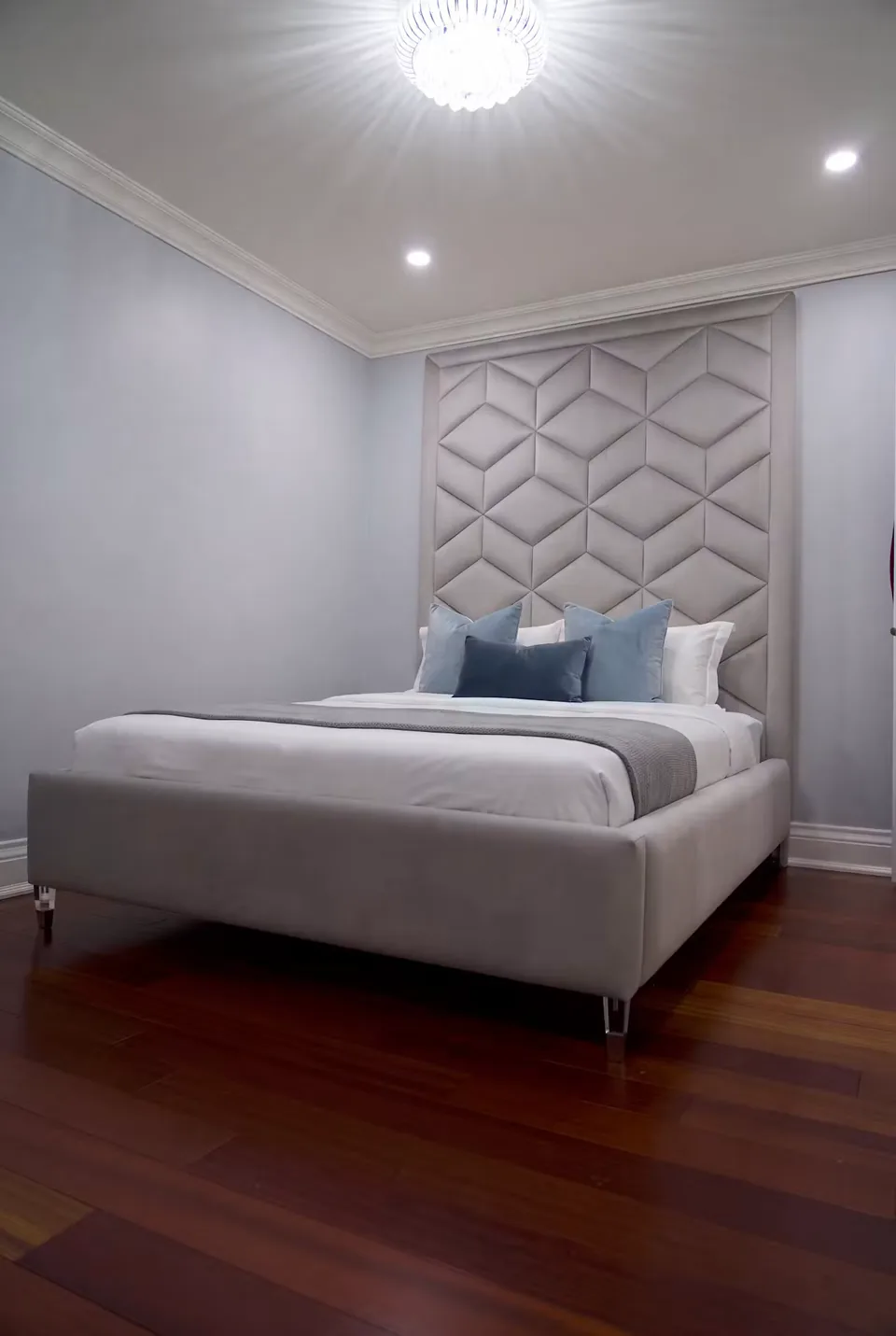Angled view of the silver bed and metal feet on a wood floor