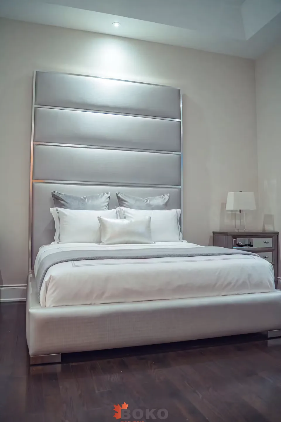 Front view of the grey bed beneath the bordered horizontal headboard
