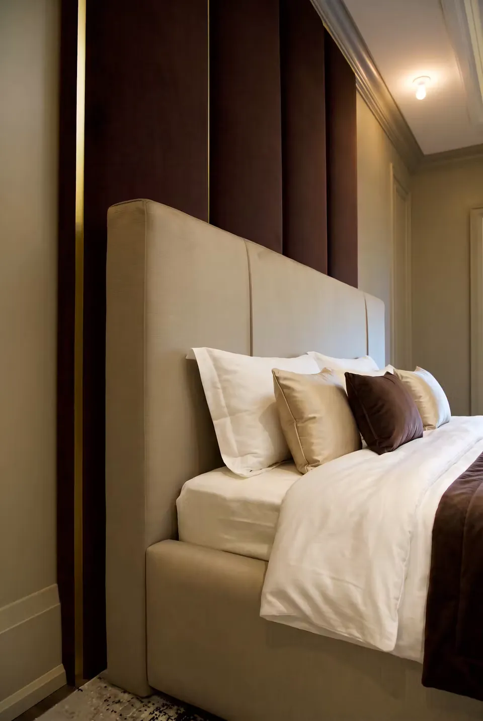 Side view of the slate headboard and brown upholstered wall panels.