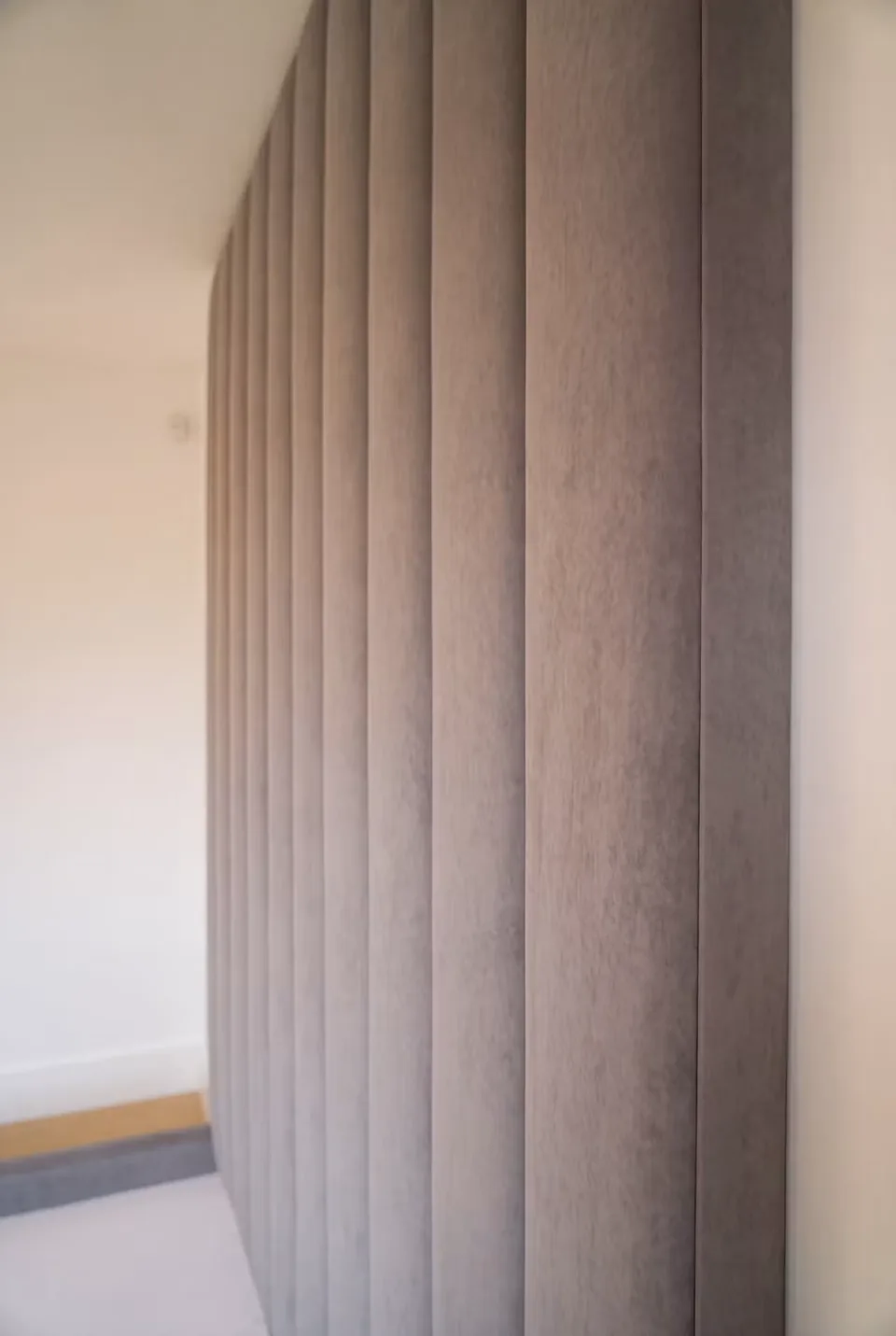 Close view of the narrow padded channels along the side of the grey headboard