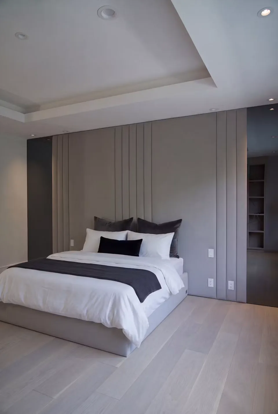 Full angled view of the bed and broad taupe padded backdrop