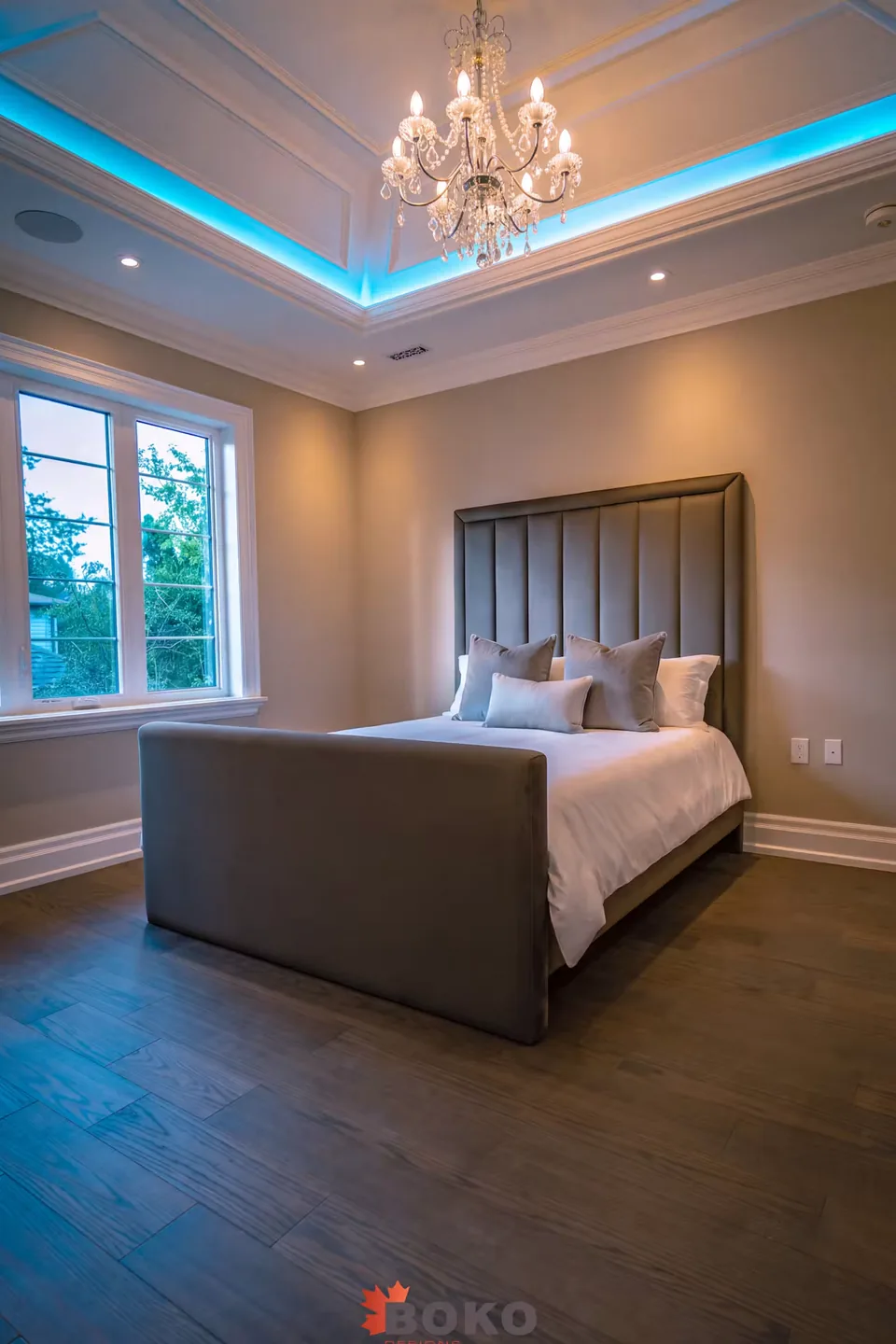 Full angled view of the taupe bed with vertical channels and high footboard