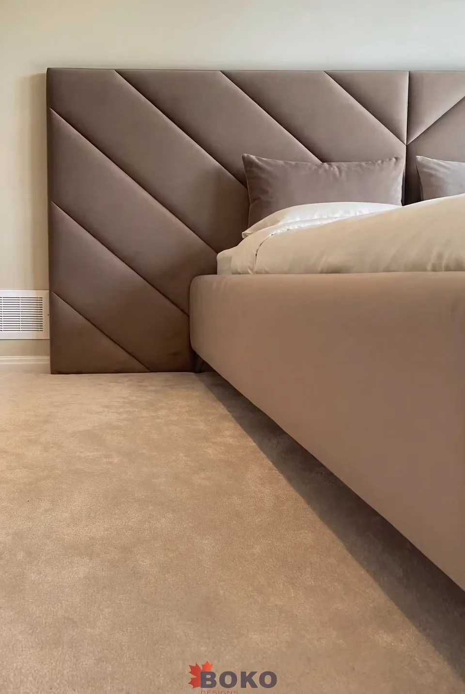 Side view of the taupe upholstered frame and padded wall edge