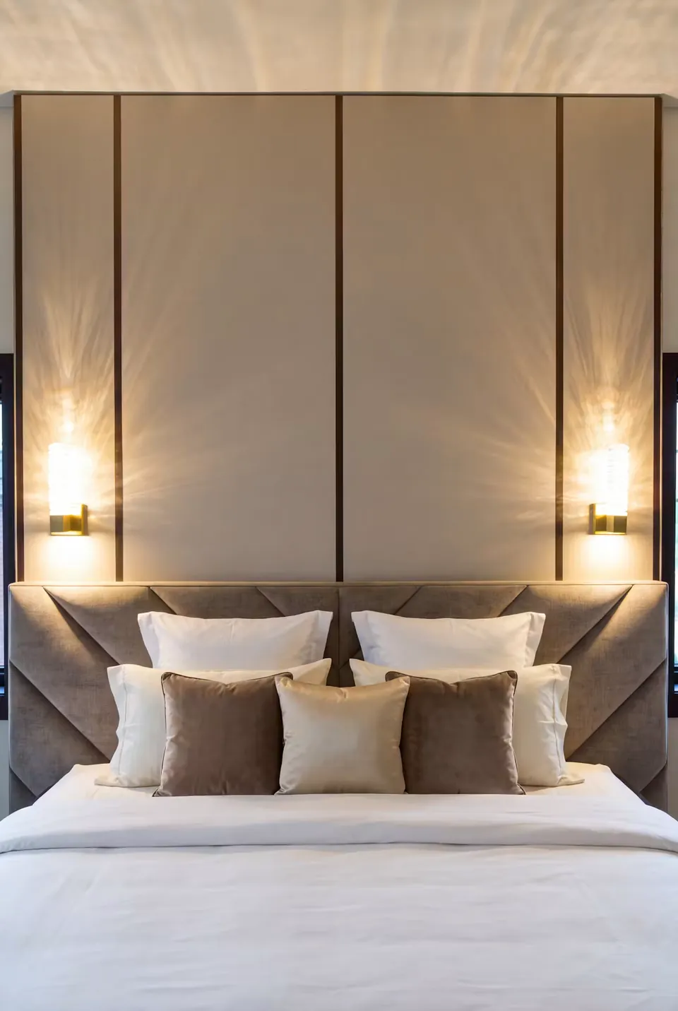 Front detail of tall taupe panels above a diagonally padded lower headboard.