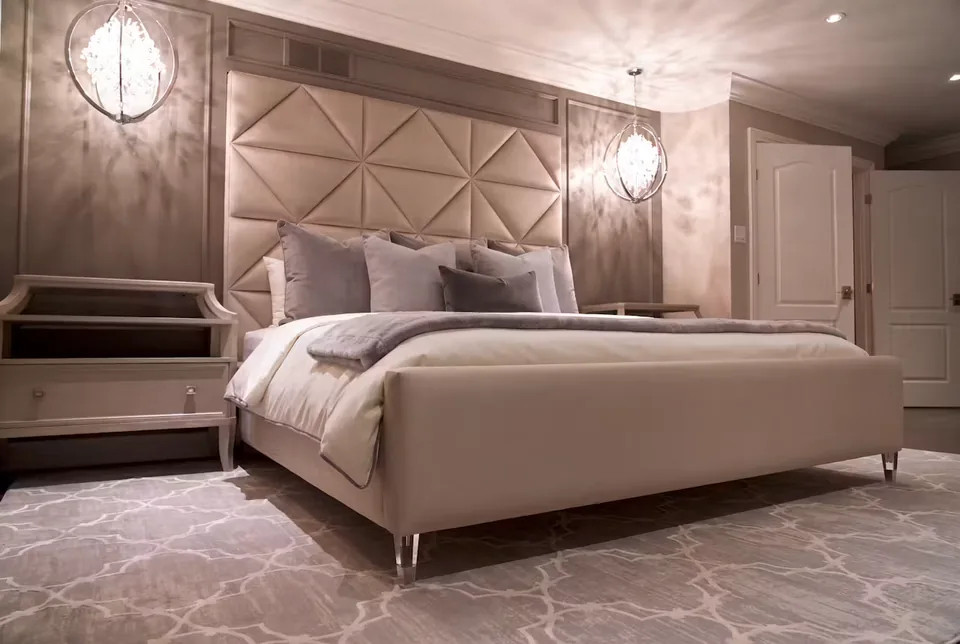 Wide angled view of the taupe bed, triangular panels and bedside units