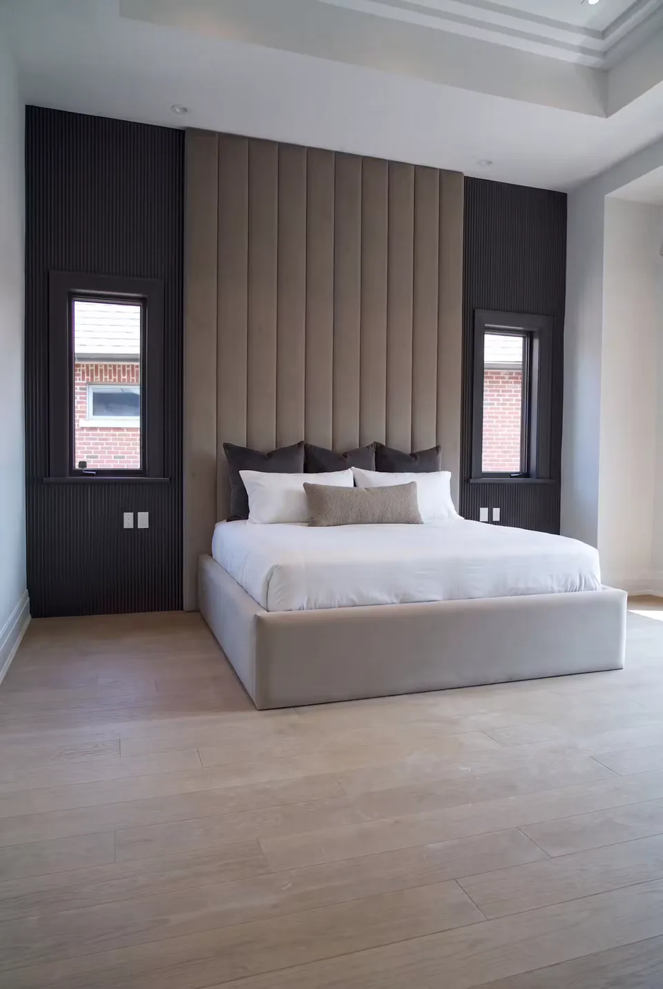 Wide view of the pale bed and channelled backdrop in a dark wall