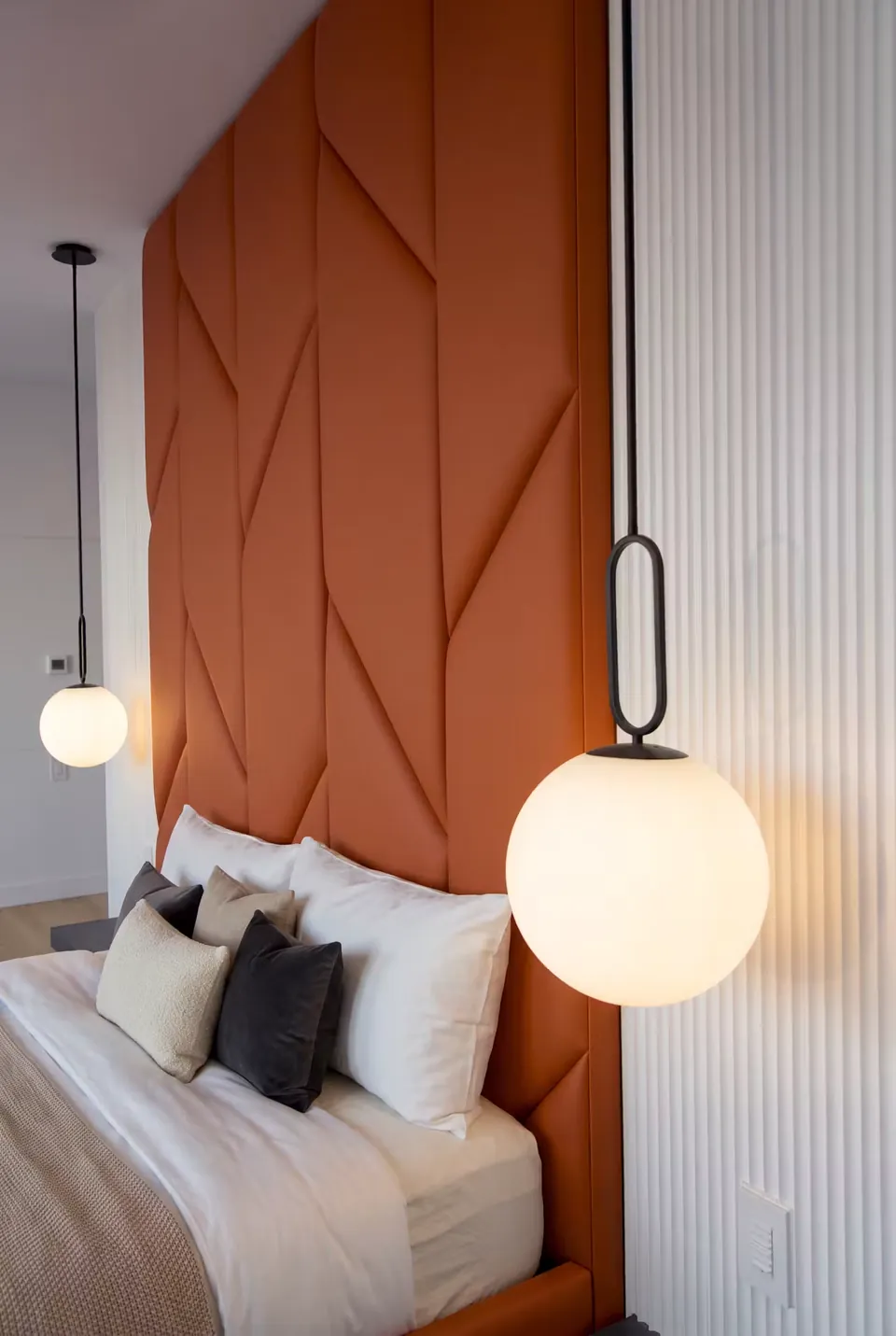 Close angled view of terracotta headboard panels and pale fluted wall sections.