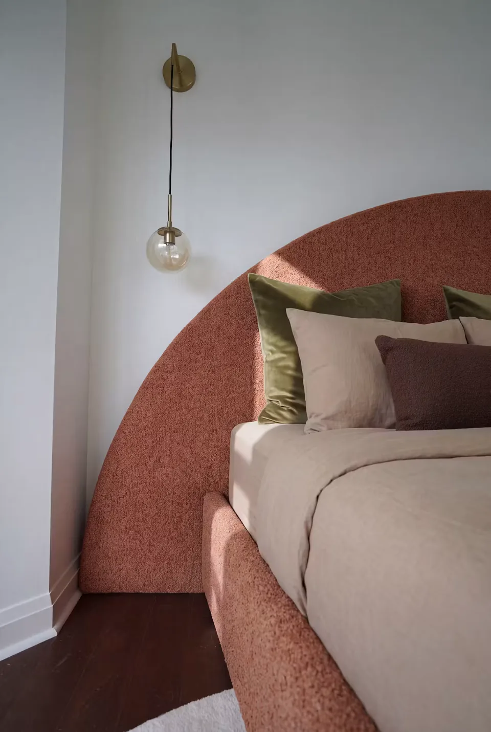 Close view of the rounded headboard and textured terracotta side rail