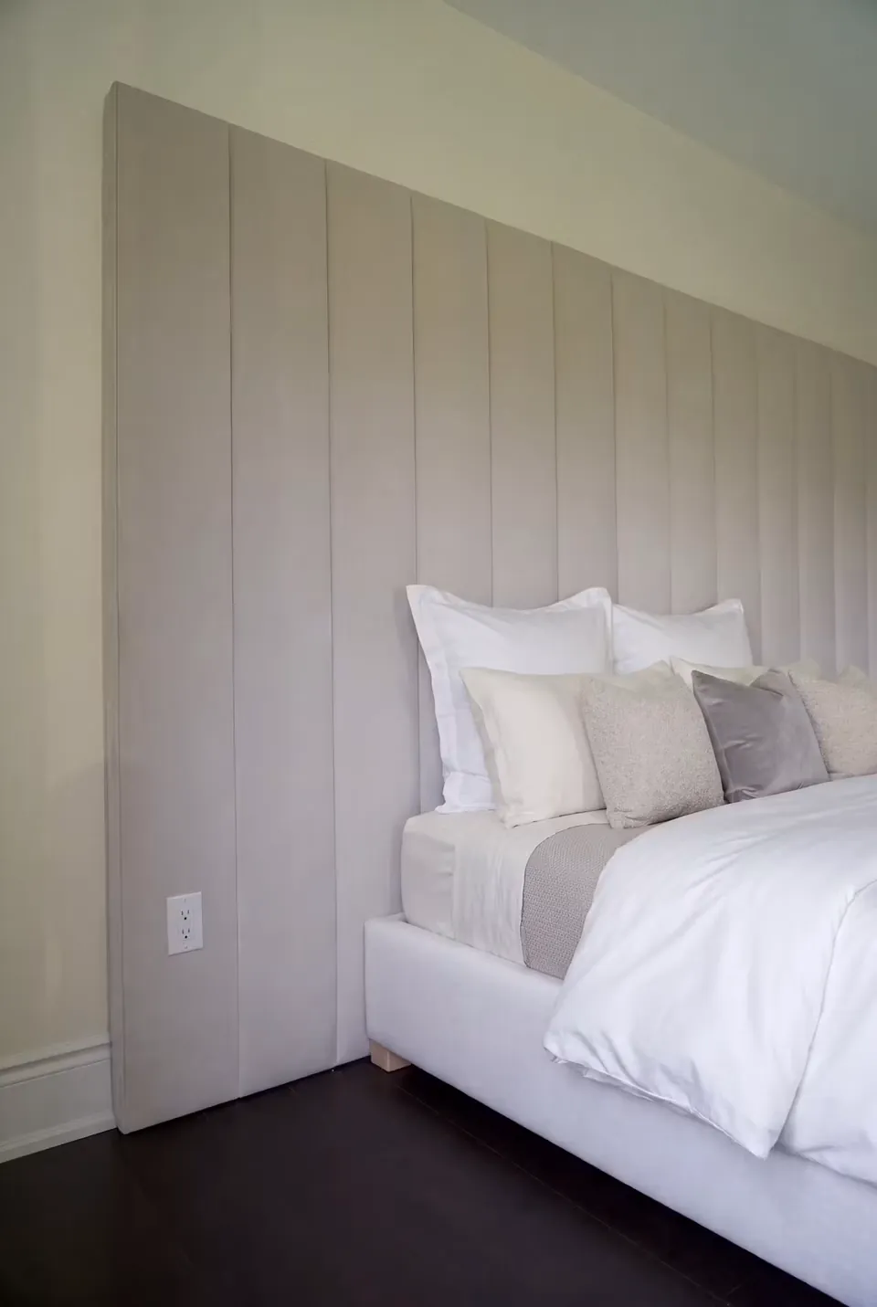 Side detail of the white upholstered frame and extended channel headboard.