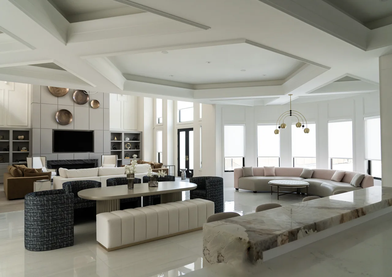 Bright living and dining room with a curved grey sofa, channelled bench and blue chairs